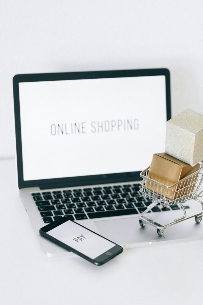 pexels photo 6214479 6214479 1 Minimalist setup showcasing online shopping with a laptop and miniature cart.