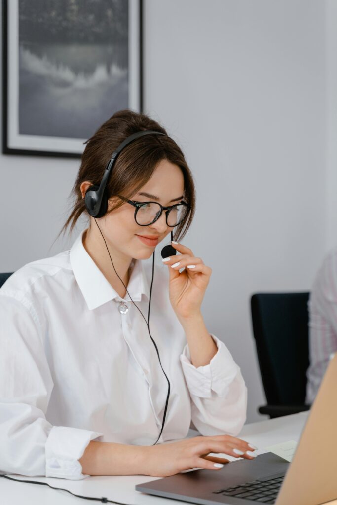 pexels photo 7709287 7709287 Professional woman using headset for customer service in office setting.